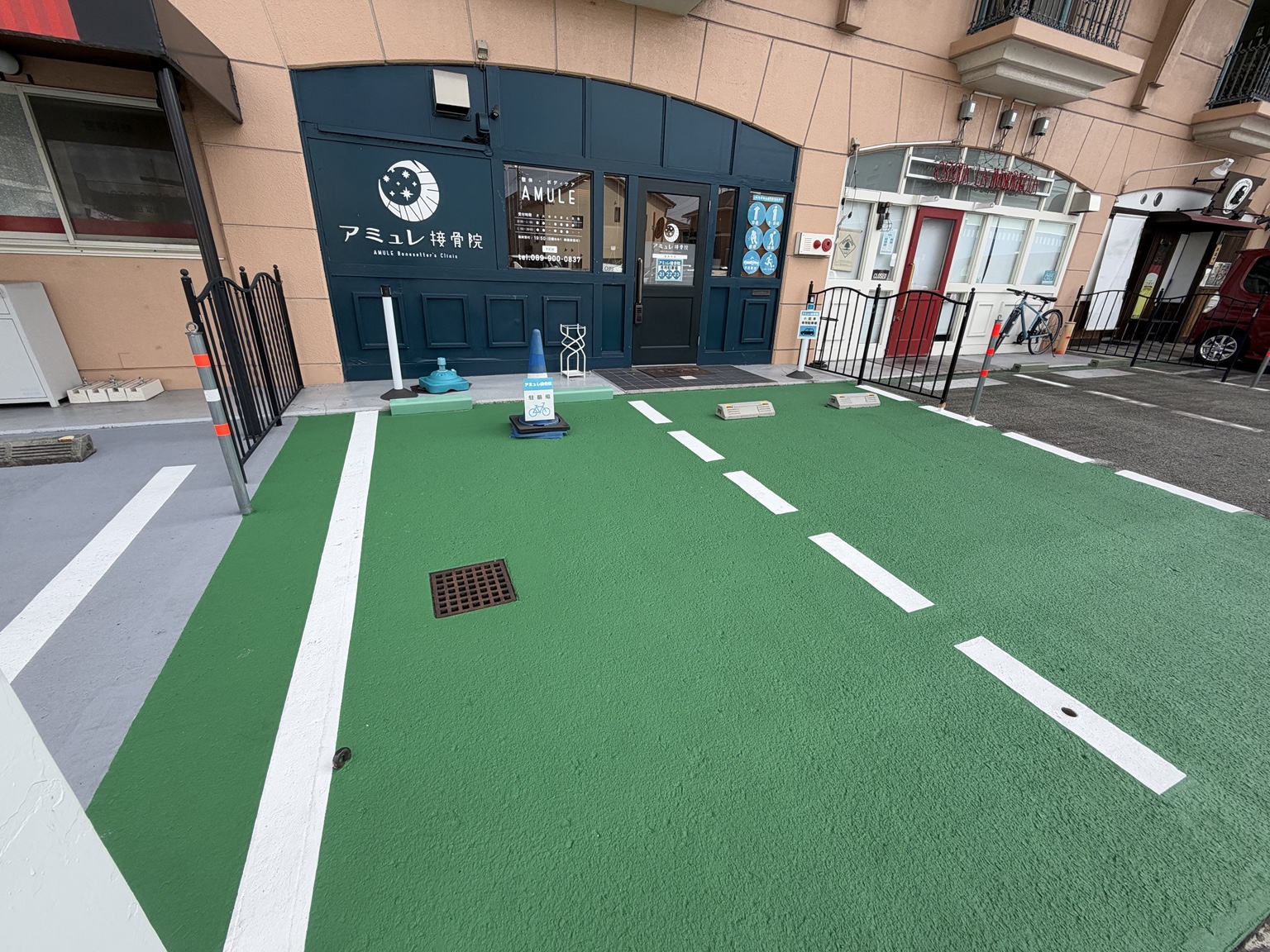 店舗前の緑の区画。写真に向かって左側は自転車・バイク専用、右側は軽自動車・小型車専用。
